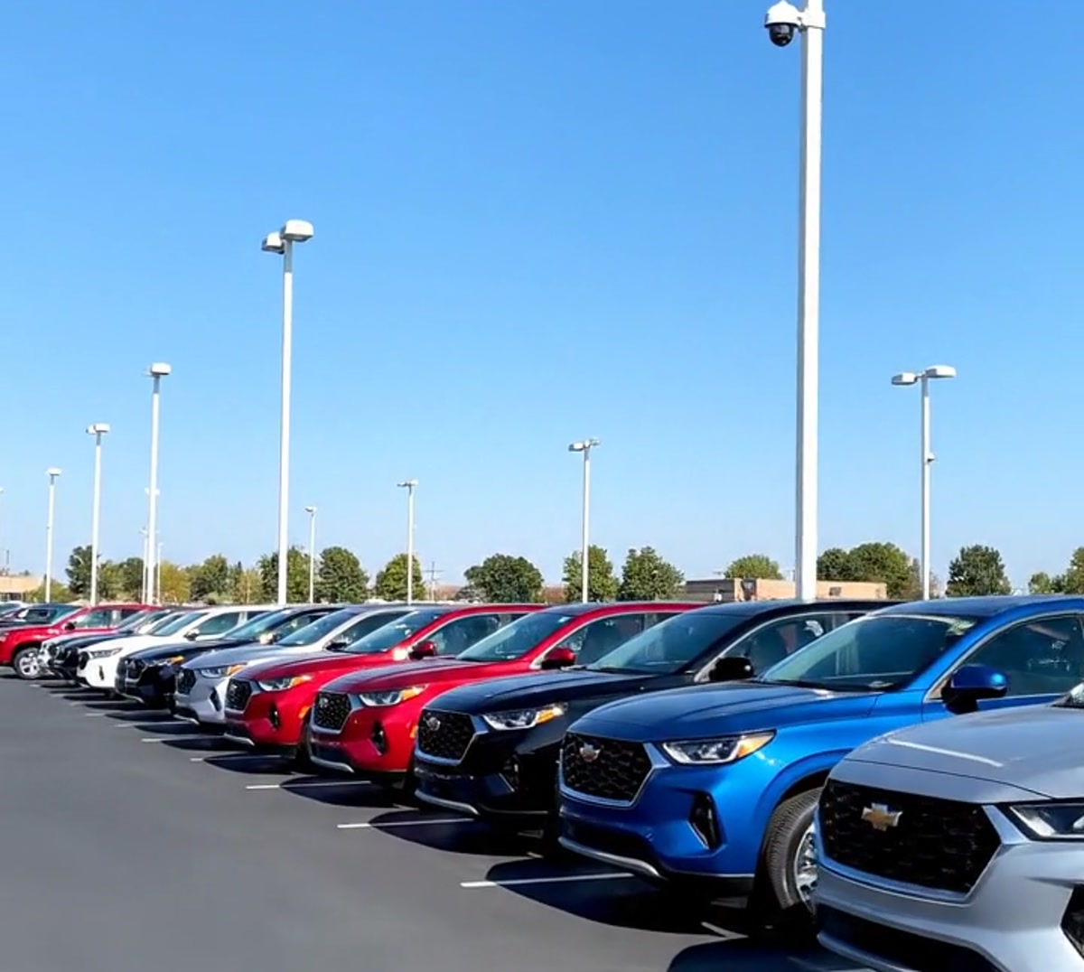 car dealership lot at night — rows of vehicles